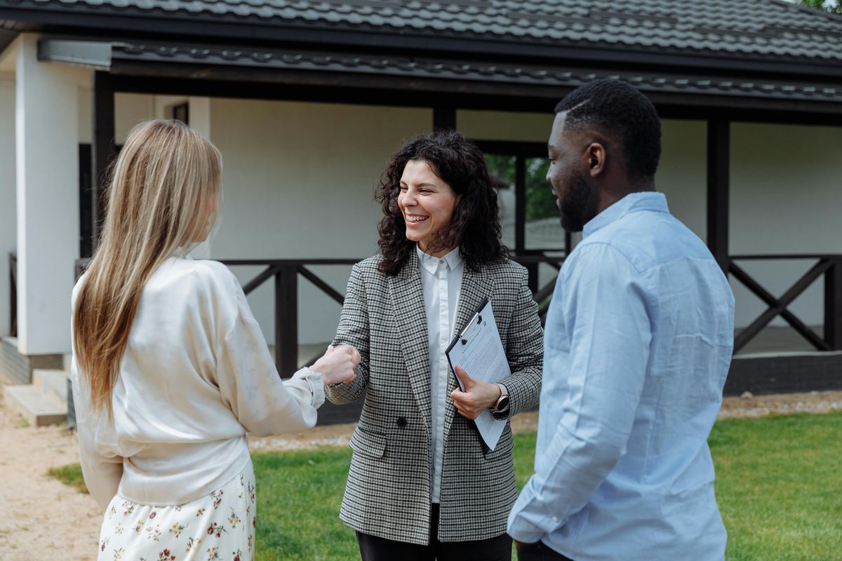 Real estate agent greeting homebuyers at property